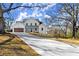 Stunning two-story home with a long driveway, a brown garage door, and lush trees at 2801 Univeter Rd, Canton, GA 30115