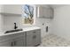 Bright laundry room featuring gray cabinets, light quartz countertops, and patterned tile flooring at 2801 Univeter Rd, Canton, GA 30115