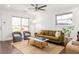 Bright living room with a modern ceiling fan, stylish furnishings, and sleek dark hardwood flooring at 1244 Lorenzo Sw Dr, Atlanta, GA 30310