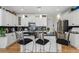 Kitchen featuring white cabinets, black countertops, a tile backsplash, stainless steel appliances, and modern pendant lighting at 3470 Serenade Nw Commons, Kennesaw, GA 30152