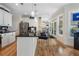 Charming kitchen featuring white cabinets, black countertops, an island, and hardwood floors near the back door at 3470 Serenade Nw Commons, Kennesaw, GA 30152