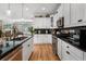 Updated kitchen featuring white cabinets, black countertops, stainless steel appliances, and hardwood floors at 3470 Serenade Nw Commons, Kennesaw, GA 30152