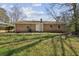 This backyard has a brick house with a door, some trees and grass at 2235 Chamois Ct, Decatur, GA 30035