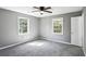 Spacious bedroom with soft carpet, ceiling fan, two bright windows, and neutral paint at 2235 Chamois Ct, Decatur, GA 30035