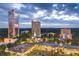 An aerial view of a shopping center surrounded by tall buildings and lush greenery at dusk at 2881 Peachtree Ne Rd # 704, Atlanta, GA 30305