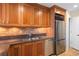 Kitchen features wooden cabinets, stainless steel appliances, granite countertops, tile backsplash and wine storage above a refrigerator at 2881 Peachtree Ne Rd # 704, Atlanta, GA 30305