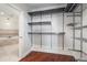 Spacious walk-in closet with custom shelving and hardwood floors, leading to a luxurious bathroom with a soaking tub at 2881 Peachtree Ne Rd # 704, Atlanta, GA 30305