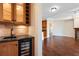 View of a wet bar with wooden cabinets, wine storage, tile backsplash, and a beverage refrigerator in an open floor plan at 2881 Peachtree Ne Rd # 704, Atlanta, GA 30305