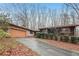 Charming single-story home with brick and dark siding, front yard landscaping and two-car garage at 357 Forest Lake Rd, Lawrenceville, GA 30046