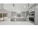 Modern kitchen with grey cabinets, black hardware, stainless steel appliances, marble backsplash, quartz countertops and pendant lighting at 4013 Brenteresa Ct, Snellville, GA 30039