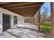 Covered back patio with concrete flooring and wood post beams, next to the backyard at 4013 Brenteresa Ct, Snellville, GA 30039