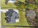 Aerial view of a home with a large roof, big yard, and mature trees surrounding the property at 1011 Nours Cir, Lawrenceville, GA 30045