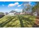 Extensive backyard featuring a manicured lawn, mature trees, and privacy fencing at 1011 Nours Cir, Lawrenceville, GA 30045