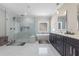 Bright bathroom featuring a glass shower, soaking tub, black cabinets, and marble countertops at 1011 Nours Cir, Lawrenceville, GA 30045