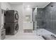 Modern bathroom featuring a glass shower, stacked washer and dryer, and white vanity at 1011 Nours Cir, Lawrenceville, GA 30045