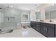 Bright bathroom with marble floors, glass enclosed shower, soaking tub, and and sinks at 1011 Nours Cir, Lawrenceville, GA 30045