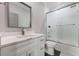 Bathroom with single sink vanity, white cabinets, and shower with glass doors at 1011 Nours Cir, Lawrenceville, GA 30045