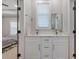 Bathroom featuring dual sinks, a large mirror, and white cabinets, accessible through the bedroom at 1011 Nours Cir, Lawrenceville, GA 30045