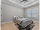 Bedroom featuring a tray ceiling, neutral paint, hardwood floors, and plush carpet at 1011 Nours Cir, Lawrenceville, GA 30045