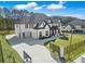 Elegant white home with a three-car garage, a spacious driveway, and a manicured lawn at 1011 Nours Cir, Lawrenceville, GA 30045