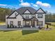 Stunning two-story home with a modern white exterior, black trim, and a lush green lawn at 1011 Nours Cir, Lawrenceville, GA 30045