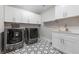 Laundry room with washer, dryer, sink, countertop, and ample cabinet space at 1011 Nours Cir, Lawrenceville, GA 30045
