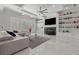 Bright living room with sleek white marble floors, built in shelves, fireplace, and stylish fan at 1011 Nours Cir, Lawrenceville, GA 30045