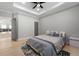 Bright main bedroom with tray ceiling, ceiling fan, and light hardwood floors at 1011 Nours Cir, Lawrenceville, GA 30045