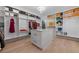 Custom walk-in closet with extensive shelving, a dressing island, and hardwood floors at 1011 Nours Cir, Lawrenceville, GA 30045