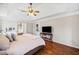 Main bedroom with tray ceilings, hardwood floors, ensuite bathroom, and console table at 1208 Cotton Gin Dr, Powder Springs, GA 30127