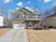 Two-story brick home with a two-car garage, covered porch, and manicured lawn at 5160 Bucknell Trce, Cumming, GA 30028