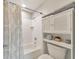 Clean bathroom featuring a shower with patterned curtain, white tiled walls, and cabinet for toiletries at 66 Goldrush Ne Cir, Atlanta, GA 30328