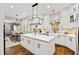 Spacious white kitchen with a marble island, modern lighting, and hardwood floors at 25 Sherman Nw Ln, Cartersville, GA 30121