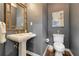 Elegant powder room featuring a unique mirror, pedestal sink, stylish fixtures, and a toilet for your convenience at 155 Oakpark Ct, Mcdonough, GA 30253