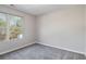 A simple bedroom with light gray walls, gray carpet, and a window overlooking trees at 2201 Fairington Village Dr, Lithonia, GA 30038