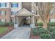 Close-up of an apartment building entrance with stairs, landscaping, and a covered walkway at 2201 Fairington Village Dr, Lithonia, GA 30038
