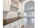 Stylish bar area with white cabinets, granite countertops, and a wine rack overlooking a bright living space at 3772 Sunbridge Dr, Snellville, GA 30039