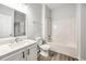 Clean bathroom with a white vanity, toilet, and shower-tub combo, complemented by gray wood-look floors at 3772 Sunbridge Dr, Snellville, GA 30039