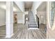 Bright foyer with soaring ceilings, a staircase with black iron railings, and gray wood-look floors at 3772 Sunbridge Dr, Snellville, GA 30039