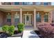 Inviting front porch with brick columns and an oval glass front door surrounded by green and maroon bushes at 3772 Sunbridge Dr, Snellville, GA 30039