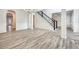 Open-concept living room featuring gray wood-look floors, wainscoting, and a staircase with black iron railings at 3772 Sunbridge Dr, Snellville, GA 30039