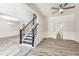Spacious living room with gray wood-look floors, white wainscoting, a ceiling fan, and a staircase at 3772 Sunbridge Dr, Snellville, GA 30039