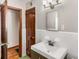 Bathroom featuring vanity sink, white tile, and wood trim, and door to hallway at 461 Deckner Sw Ave, Atlanta, GA 30310