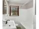 Bathroom featuring white tile, toilet, tub and shower combo, vanity, and window at 461 Deckner Sw Ave, Atlanta, GA 30310