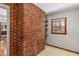 Bright sunroom featuring a red brick wall, neutral tile flooring, window, and shelving at 461 Deckner Sw Ave, Atlanta, GA 30310
