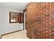 Bright sunroom featuring red brick wall, neutral tile flooring, window, and shelving at 461 Deckner Sw Ave, Atlanta, GA 30310