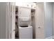 A compact laundry area featuring a stacked washer and dryer unit with white folding doors at 808 Dixie Ne Ave, Atlanta, GA 30307