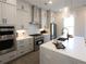 Modern kitchen featuring stainless steel appliances, white cabinets, and a stylish island with quartz countertops at 3552 Cedarvale Ct, Powder Springs, GA 30127