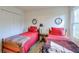 Bright bedroom featuring twin beds with wood frames, red bedding, and light walls at 245 Dennis Dr, Alpharetta, GA 30009