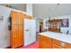 View of the kitchen with white refrigerator, wood cabinets, and adjoining dining area at 245 Dennis Dr, Alpharetta, GA 30009